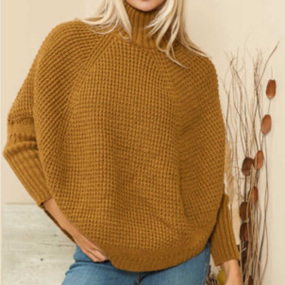 Turtleneck poncho with sleeves.